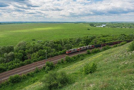景观顶视图摄影照片_机车通过俄罗斯铁路的货运列车，沿着典型的俄罗斯景观，顶视图