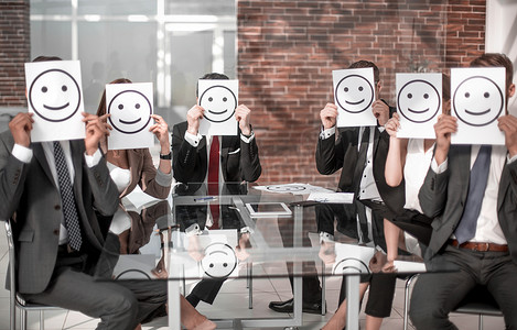 业务团队让笑脸图标坐在办公桌前