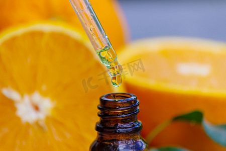 瓶装橙油，背景为新鲜水果片。
