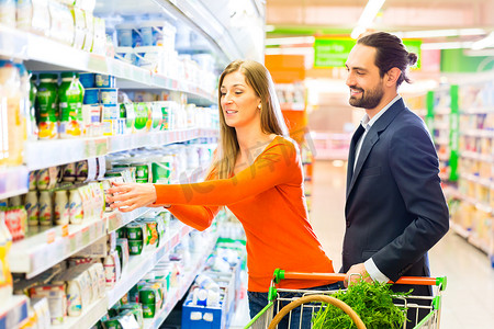 夫妇在大型超市中选择冷却产品