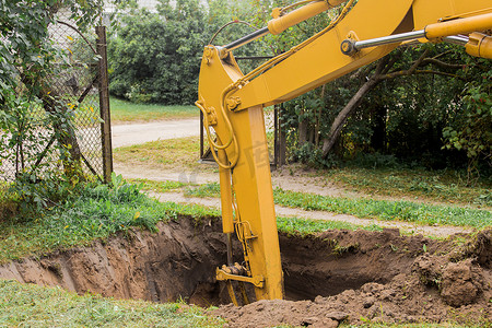 挖掘机的液压活塞在施工现场用工业铲斗深挖坑