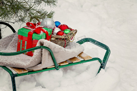 雪橇、毯子、带玩具的篮子和雪天的礼品盒