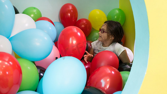 两个可爱的女孩一边玩着五颜六色的气球一边聊天