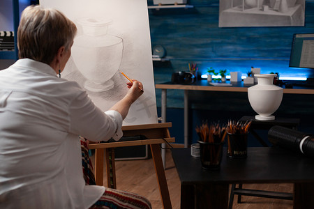 专注于退休艺术教师在纸画布上用铅笔画静物花瓶模型创作艺术作品