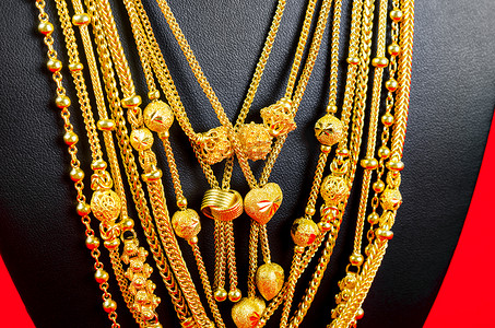 项链展示架，红色天鹅绒面料上配有金项链。