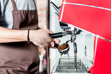 咖啡师在咖啡馆的 portafilter 机器上准备咖啡