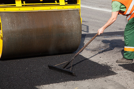 公路施工期间在砾石基层顶部铺设新鲜沥青或沥青的路面机械。