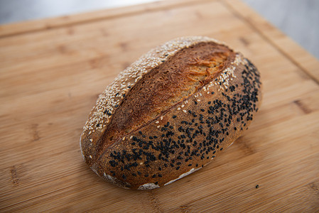 工艺面包在木质背景上撒上白芝麻和黑芝麻，并有复制空间