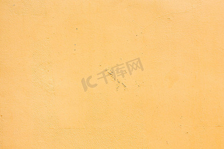 有剥落的油漆背景/织地不很细的黄色混凝土被风化的墙壁。