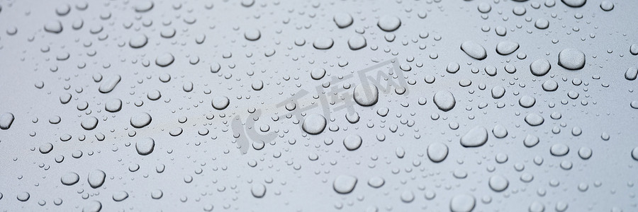 玻璃上的水滴，灰色背景，特写