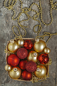 圣诞球红色摄影照片_圣诞球红色和金色，珠子躺在木篮顶部 v