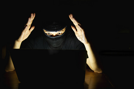 计算机黑客在暗室里用笔记本电脑做工作 — 有计算机犯罪概念的人