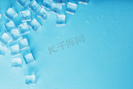 半透明红条摄影照片_蓝色背景上散落着许多带水滴的冰块
