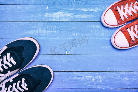 两双运动鞋，蓝色男式运动鞋和红色女式运动鞋
