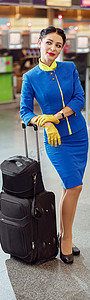 空乘人摄影照片_带着旅行手提箱的空乘人员站立在机场航站楼