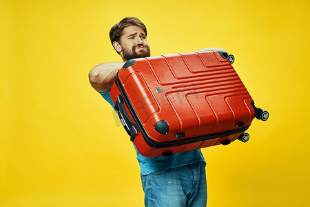 拿行李的人摄影照片_手里拿着沉重行李的男人旅行旅行乘客