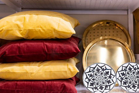 舒适的枕头套，枕套由不同材料和质地的纺织品制成。沙发装饰上的舒适枕头。内部有架子和彩色枕头和盘子