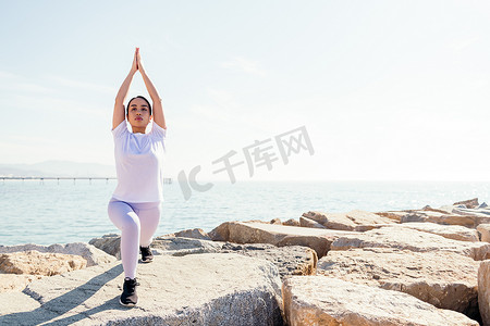 正能量摄影照片_年轻的亚洲女人在海边练习瑜伽