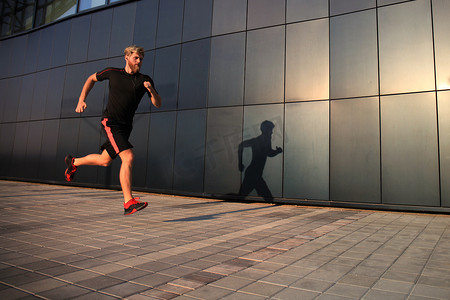 运动的年轻人在户外跑步以保持健康，在日落或日出。