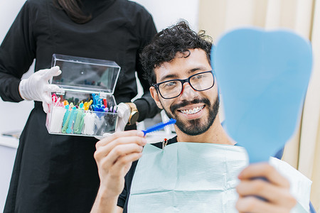 正畸病例摄影照片_牙医与病人选择金属牙套，牙医与病人选择橡皮筋，牙医与病人选择牙套