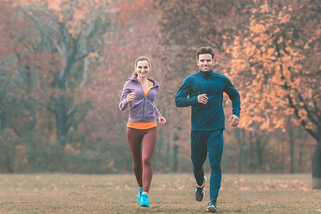 夫妇在美丽的秋天风景中跑步以更好地健身