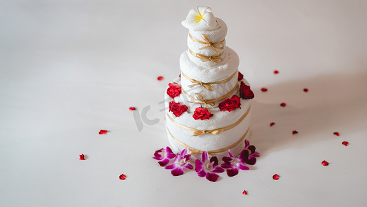 喜庆周年庆典摄影照片_用毛巾蛋糕在床上庆祝惊喜。
