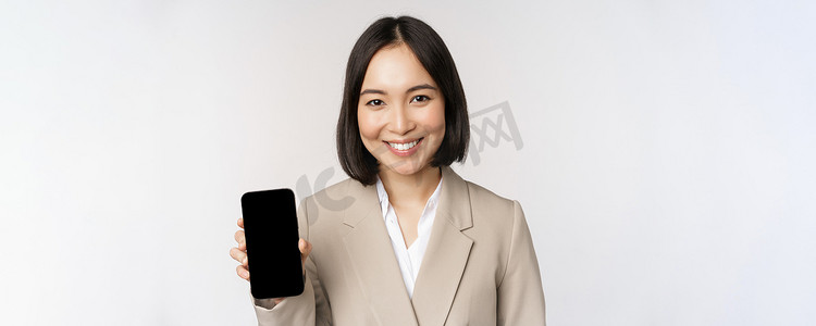 显示智能手机应用程序界面、手机屏幕、站在白色背景上的亚洲企业女性肖像