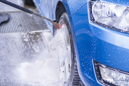在室外洗车场用加压水手动洗车。使用高压水清洗汽车。