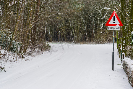 警告语摄影照片_荷兰警告交通标志，恶劣天气条件下的危险转弯，小心危险转弯