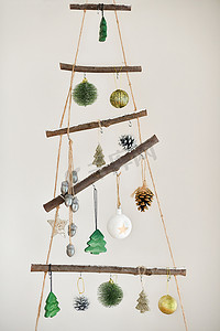 赶车鞭子摄影照片_挂在墙上的手工木制圣诞树