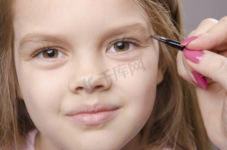 化妆师给女孩的脸上画眉毛