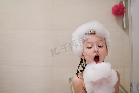 浴缸摄影照片_小女孩在洗澡玩肥皂泡沫