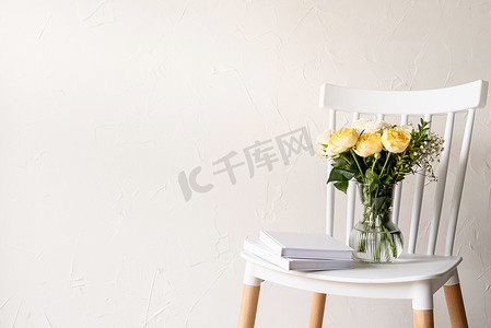 玫瑰花粥摄影照片_简约的家居内饰，配有时尚的椅子、一束新鲜的玫瑰和书籍