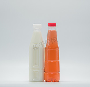 创意瓶中摄影照片_白色背景现代塑料包装中的豆奶和软饮料