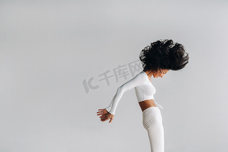 健身房运动卡摄影照片_一位身穿白色运动服的女士正在瑜伽馆进行动态卡利冥想