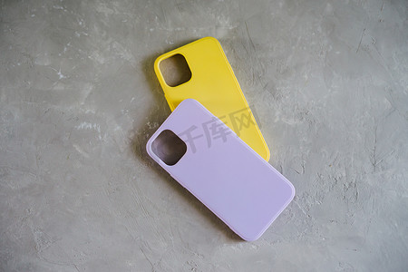 智能手机的黄色和淡紫色保护壳。