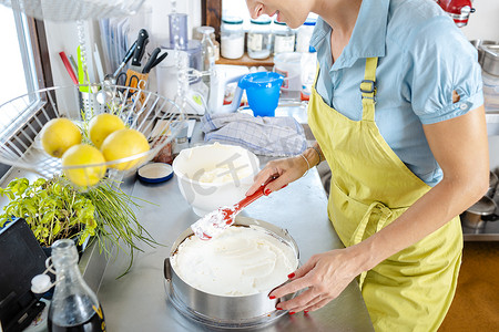 蛋糕厨师女摄影照片_准备蛋糕的女厨师