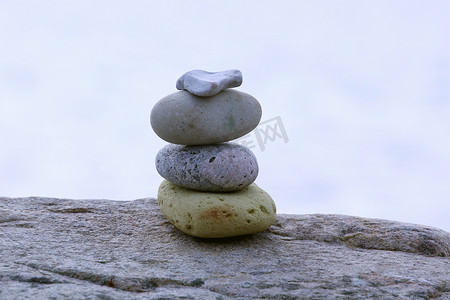 日落时圆石滩上平衡的石头。