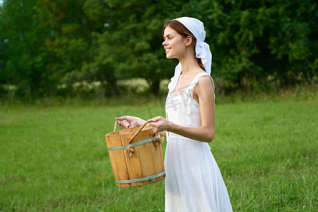 穿裙子的女人摄影照片_户外村里穿白裙子的女人绿草农夫