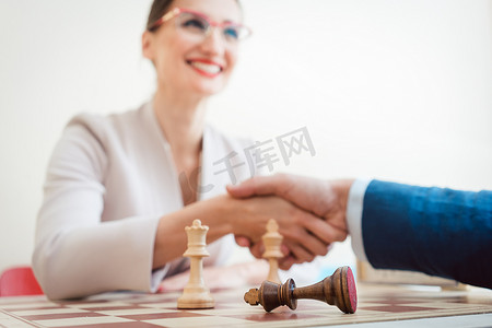 商务谈判男人摄影照片_下棋后商务男女握手