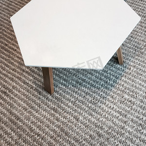 灰色针织地毯上的现代白色桌子