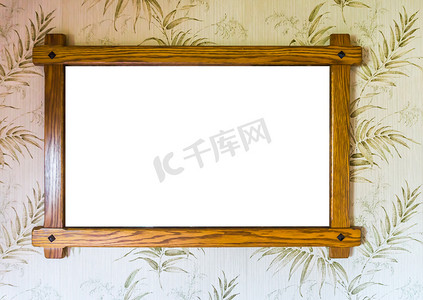 壁纸墙上的相框摄影照片_挂在墙上的空棕色木制相框，装饰有壁纸背景