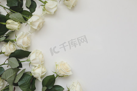 优雅的花框由白玫瑰制成，并放置在白色背景上的文字