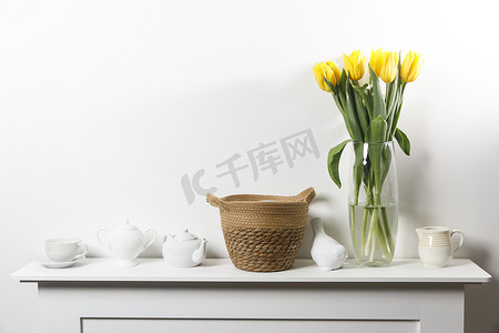 邀请函模板摄影照片_白桌玻璃花瓶中的黄色郁金香花束