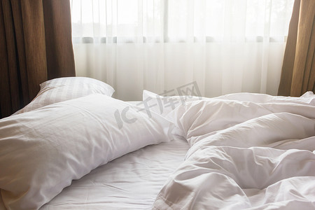 卧室床上的白色枕头和毯子，上面有皱纹，凌乱，m