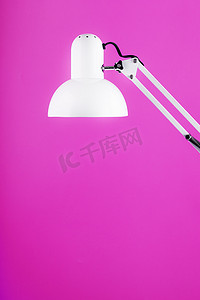 粉红色背景中的白色台灯，带有文本和创意概念的空间