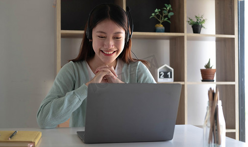 课程设置摄影照片_聪明的亚洲学生在互联网上在线学习和与朋友会面以在家中的笔记本电脑上搜索信息时会感到满足。