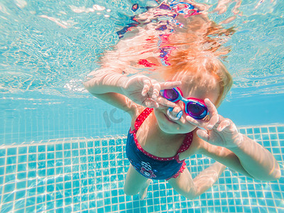 水上乐园里的小女孩在水下游泳微笑