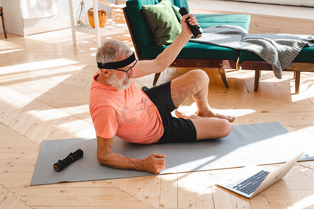老人在家用哑铃做健身运动 — 老年人与健康概念