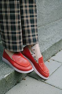 穿着格子裤和红鞋的女人的腿